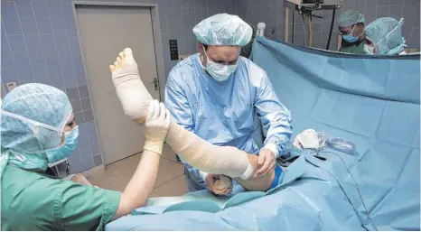  ?? FOTO: IMAGO ?? Letzter Ausweg OP: Ein Arzt bandagiert das Bein eines Patienten nach einer Krampfader-Behandlung.