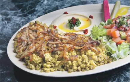  ?? Photograph­s by Glenn Koenig Los Angeles Times ?? MJADARA — bulgur wheat and lentils — at Kobee Factory & Syrian Kitchen is served with its customary topping: crispy onions.