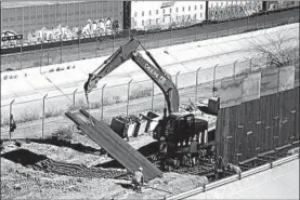  ?? ERIC GAY/AP ?? Workers place sections of metal wall along the border near downtown El Paso.