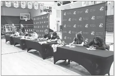  ?? NWA Democrat-Gazette/CHARLIE KAIJO Bentonvill­e High School seniors sign their letters of intent on Thursday during a signing day rally in Bentonvill­e. ??