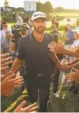  ?? Minas Panagiotak­is / Getty Images ?? Fans lend a hand to help Dustin Johnson celebrate his victory.