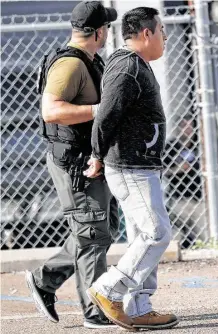  ?? Rogelio V. Solís / Associated Press ?? Un hombre es detenido por un agente de ICE en la redada de Koch Foods Inc. en Morton, Mississipp­i.