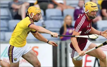  ??  ?? Wexford full-back Darren Byrne trying to keep tabs on Galway’s Seán Bleahene who was re-introduced to sco
