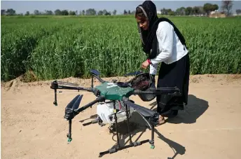  ?? ?? Himanshi, a certified remote pilot trained under the government-backed ‘Drone Sister’ programme, pouring liquid fertiliser into a drone, to spray it over a farm in Pataudi.