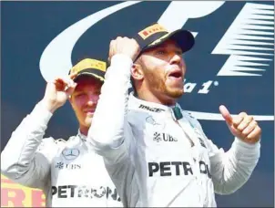  ?? AFP ?? Mercedes driver Lewis Hamilton (right) celebrates on the podium with teammate Nico Rosberg after winning the Hungarian Grand Prix at the Hungarorin­g yesterday.