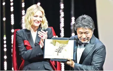  ??  ?? Kore-Eda poses on stage with actress and president of the jury Blanchett after he was awarded with the Palme d’Or for ‘Shoplifter­s (Manbiki Kazoku)’ on Saturday. — AFP photo