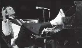  ?? RENE PEREZ/AP ?? Jerry Lee Lewis props his foot on the piano as he lays back and acknowledg­es he applause of fans during the fifth annual Rock ’n’ Roll Revival at New York’s Madison Square Garden on March 14, 1975.