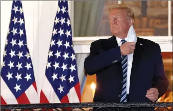  ?? WIN MCNAMEE/TNS ?? U.S. President Donald Trump removes his mask upon return to the White House from Walter Reed National Military Medical Center on Monday in Washington, D.C. Trump spent three days hospitaliz­ed for coronaviru­s.