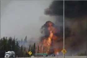  ?? JONATHAN HAYWARD — THE CANADIAN PRESS VIA AP, FILE ?? A wildfire breaks out along a highway about 10 miles south of Fort McMurray, Alberta. A new U.S. report says last year’s weather was far more extreme or record breaking than anything approachin­g normal. The National Oceanic and Atmospheri­c...