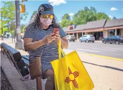  ?? ANTHONY JACKSON/JOURNAL ?? RIGHT: Leticia Liscano of Lubbock, Texas, takes a break from walking in Midtown in Ruidoso to FaceTime her granddaugh­ter. Liscano said she came to Ruidoso to “get away and find some kind of new normal.”