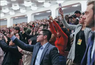  ?? WANG ZHUANGFEI / CHINA DAILY ?? Journalist­s from around the world take photos during the closing meeting of the second session of the 14th National People’s Congress in Beijing on Monday.