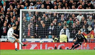  ?? PAUL HANNA / REUTERS ?? Cristiano Ronaldo fires a 97th-minute penalty past Juventus substitute goalkeeper Wojciech Szczesny on Wednesday to secure Real Madrid’s place in the Champions League semifinals. Juve won 3-1 on the night but Real advanced 4-3 on aggregate.