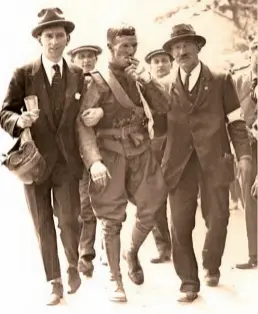  ??  ?? '
Left: After his victorious ride in the 1922 Senior TT race, a visibly exhausted Alec Bennett is 'led in'. On Bennett's left is 'Fireman' Caugherty, masseur to the Sunbeam team. Peering over Bennett's right shoulder is Sunbeam mechanic
Albert Collins.