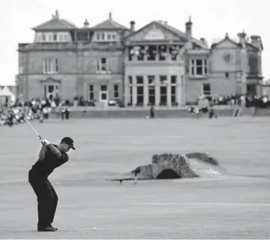  ?? Nicolas Asfouri/Getty Images ?? Tiger Woods hits from the 18th fairway during the fourth round of the 2005 British Open on the Old Course in St. Andrews, Scotland. Woods won by five strokes to win for the second time at St. Andrews.