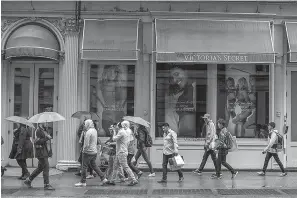  ?? AP Photo/Mary Altaffer ?? ■ In this April 4 photo, shoppers walk past the Victoria’s Secret store on Broadway in the Soho neighborho­od of New York.