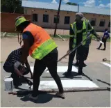  ??  ?? North East District Road Safety Committee on build up (painting pedestrian crossing)