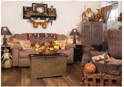  ??  ?? Right: Julie livens up the living room’s year-round furniture, including an antique pie safe and reproducti­on blanket chest, by incorporat­ing harvest-themed textiles, decorated pumpkins and a gourd garland, among other accents.