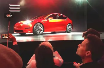  ??  ?? A Tesla Model 3 sedan, its first car aimed at the mass market, is displayed during its launch in Hawthorne, California. Tesla Inc nearly produced 5,000 Model 3 electric sedans in the last week of its second quarter, with the final car rolling off the...