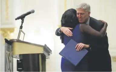  ?? Alex Wong, Getty Images ?? U.S. Supreme Court Justice Neil Gorsuch hugs Mary Elizabeth Taylor, a TFAS program alumnus of 2010 who introduced him during an event hosted by The Fund for American Studies on Thursday at Trump Internatio­nal Hotel in Washington, DC. Justice Gorsuch...