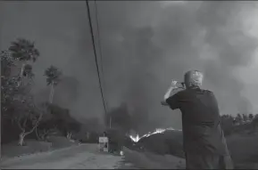  ?? GENARO MOLINA/LOS ANGELES TIMES FILE PHOTOGRAPH ?? A resident shoots video of the Woolsey fire that threatens homes along West Winding Way in Malibu on Nov. 9, 2018.