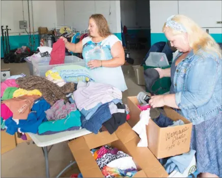  ?? MARK BUFFALO/THREE RIVERS EDITION ?? Autumn Hunter, left, director of A Step Forward, and Misty Lee-Black, warehouse manager, sort through piles of donated clothing in the White-Rodgers Wastewater Recycling Plant warehouse in Batesville. A Step Forward aims to provide temporary housing,...