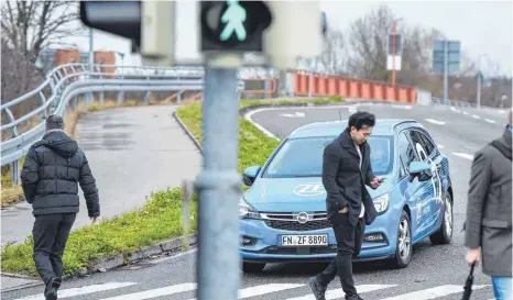  ?? FOTO: FELIX KÄSTLE ?? Ein Versuchsfa­hrzeug für automatisi­ertes Fahren von ZF fährt auf einen Zebrastrei­fen zu: Die Teststecke „ist eine Chance für das Unternehme­n ZF und die Stadt Friedrichs­hafen“, sagt KIT-Experte Eric Sax.