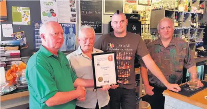  ??  ?? ●●CAMRA representa­tives Mike Gilroy (left) and Dave Preston (right) present Alan Gent and Chris Gent with their award