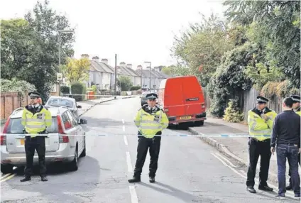  ??  ?? ► Policías británicos durante un allanamien­to ayer en Sunbury, al suroeste de Londres.