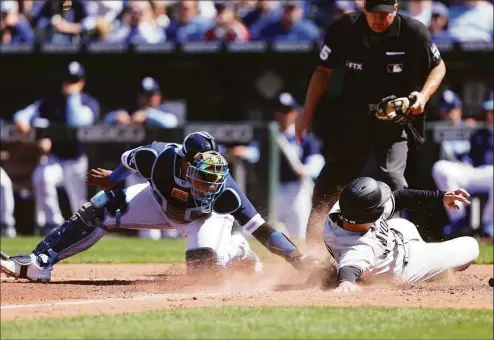  ?? Jamie Squire / Getty Images ?? The Yankees’ Anthony Rizzo, right, slides safely into home to score past the tag by the Royals’ Salvador Perez during the seventh inning Sunday.