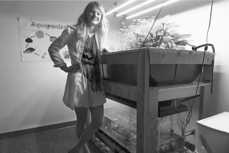  ?? COLLEEN DE NEVE/ POSTMEDIA NEWS ?? Environmen­tal science student Kelsey Morin, 24, shows off her aquaponics system, which is designed to grow edible plants using fertilizer from a fish tank.