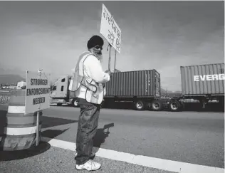  ?? CANADIAN PRESS/ DARRYL DYCK ?? Gajjan Bal holds a sign that reads ‘ Traitors Be Ashamed of Yourself’ while manning a picket line. More than 1,600 container- truck drivers are on strike.