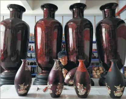  ?? PHOTOS BY PENG YOULIN / CHINA DAILY ?? Gao Guangyou paints patterns on a lacquered vase.