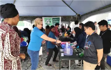  ??  ?? Dona tries her luck at the ‘Bucket and Coin Game’ as an internatio­nal student named Revelation (left) from Institute of Social Informatic and Technologi­cal Innovation, and Muhammad Akif Aizuddin Jarni from Unimas’ Faculty of Resource Science and Technology look on.