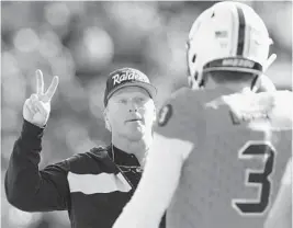  ??  ?? North coach Jon Gruden of the Raiders, talks to North quarterbac­k Drew Lock of Missouri.