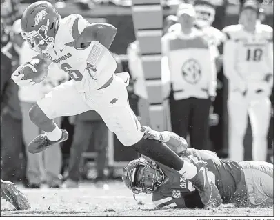  ??  ?? Arkansas Democrat-Gazette/BENJAMIN KRAIN
Arkansas running back T.J. Hammonds pulls away from Ole Miss linebacker DeMarquis Gates during the second quarter. Hammonds led the Razorbacks with 84 rushing yards on 11 carries. Gates led all defenders with...