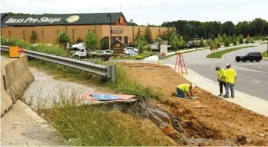  ?? STAFF PHOTO BY DOUG STRICKLAND ?? A constructi­on crew works on Camp Jordan Parkway near Interstate 75 Exit 1 on Friday in East Ridge.