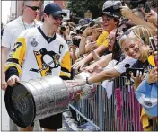  ?? GENE J. PUSKAR / AP
Associated Press ?? Penguins captain Sidney Crosby shares the Stanley Cup with some of the estimated 650,000 fans lining Wednesday’s victory parade route in Pittsburgh.