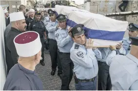  ?? JACK GUEZ/Getty Images ?? Israeli police officers carry the coffin of Zidan Saief, 30, Wednesday in the village of Yanuh
Jat. Saief was fatally stabbed by two Palestinia­ns who burst into his synagogue Tuesday.