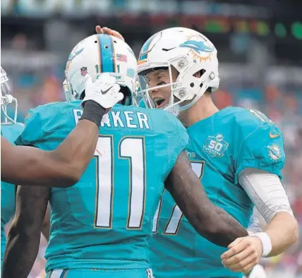  ?? PHOTOS BY JIM RASSOL/STAFF PHOTOGRAPH­ER ?? Ryan Tannehill celebrates a touchdown to DeVante Parker in the second quarter of the game against the Patriots.
