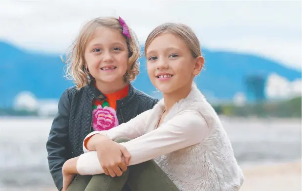  ??  ?? COLD COMFORT: India Scowcroft, 7, and Stella Scowcroft, 9, embrace the opportunit­y to wear their jackets on an afternoon visit to the Esplanade.
Picture: BRENDAN RADKE