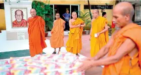  ??  ?? The Ifthar distributi­on programme starts at 5.30 pm everyday. Women and men have to stand in different queues. Left: Buddhist monks arrange packets of Ifthar meals on a table at the Dhammaraji­ka monastery. Pic Mahmud Hossain Opu/Al Jazeera