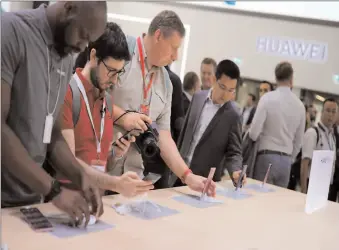  ?? -REUTERS ?? Visitors test devices at the booth of Huawei at the IFA consumer tech fair in Germany.