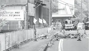  ?? — Gambar AFP ?? PERIKSA: Pekerja semalam memeriksa bahagian lebuh raya yang ditutup selepas gempa bumi yang melanda bahagian selatan Jepun pada lewat malam sehari sebelumnya di bandar Ozu, wilayah Ehime.