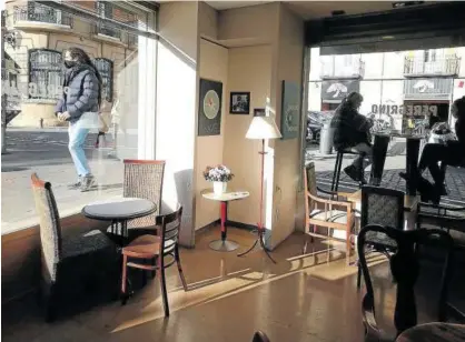  ??  ?? El interior de una cafetería, cerrado mientras dos personas se encuentran en su terraza.