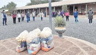  ??  ?? Padres de familia recibieron ayer los kits de alimentos en reemplazo del almuerzo escolar.