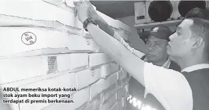  ??  ?? ABDUL memeriksa kotak-kotak stok ayam beku import yang terdapat di premis berkenaan.