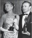  ?? THE ASSOCIATED PRESS ?? Grace Kelly, left, and Marlon Brando, hold their best actress and actor Oscars in Los Angeles. Kelly’s icy green satin gown was designed by Edith Head.