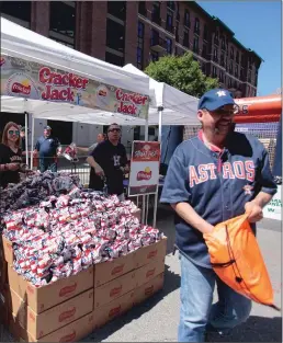  ?? Orlando Sentitnel / TNS ?? A fan visits the Cracker Jack tent during Houston Astros Fan Fest before playing the Seattle Mariners on opening day at Minute Maid Park in Houston on April 3, 2017. The famed baseball candy could be on the way out of some ball park menu’s.