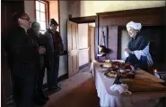  ?? BILL UHRICH — READING EAGLE ?? Courtney Stevens of Wyomissing explains the food preparatio­n during the Boone time to Kimberly Monnan, left, of Exeter Township, and her son Michael, 12, and husband Matthew Stricker during the Homestead Holiday Saturday at the Daniel Boone Homestead in Exeter Township.