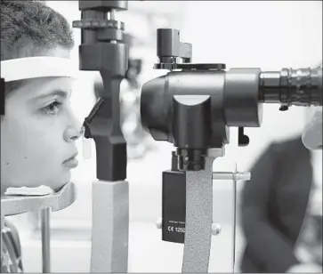  ?? Bill West Associated Press ?? PREVIOUSLY, there has been no treatment for the condition, which eventually causes complete blindness by adulthood. Above, a doctor checks the eyes of Misa Kaabali, 8, at a Philadelph­ia hospital in October.